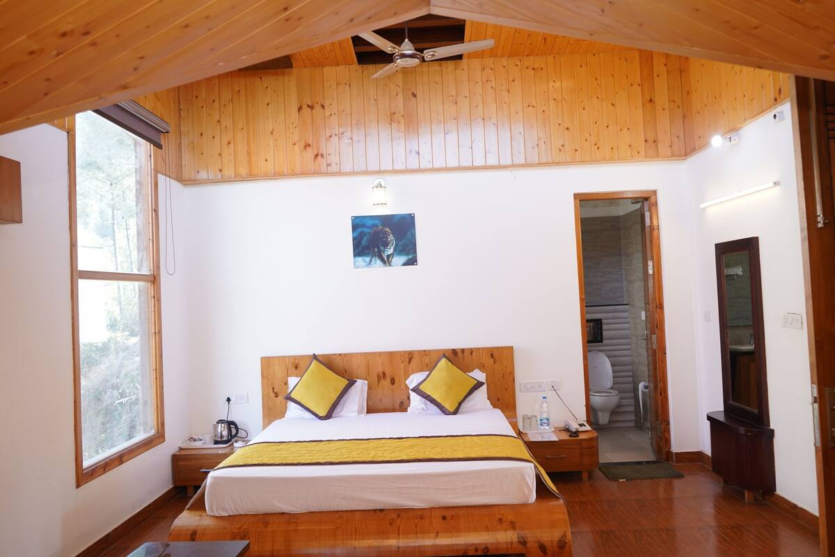 Un dormitorio con paneles de madera, una cama, una mesita de noche y un ventilador de techo.