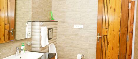 A bathroom with a sink, toilet, and wooden cabinets.
