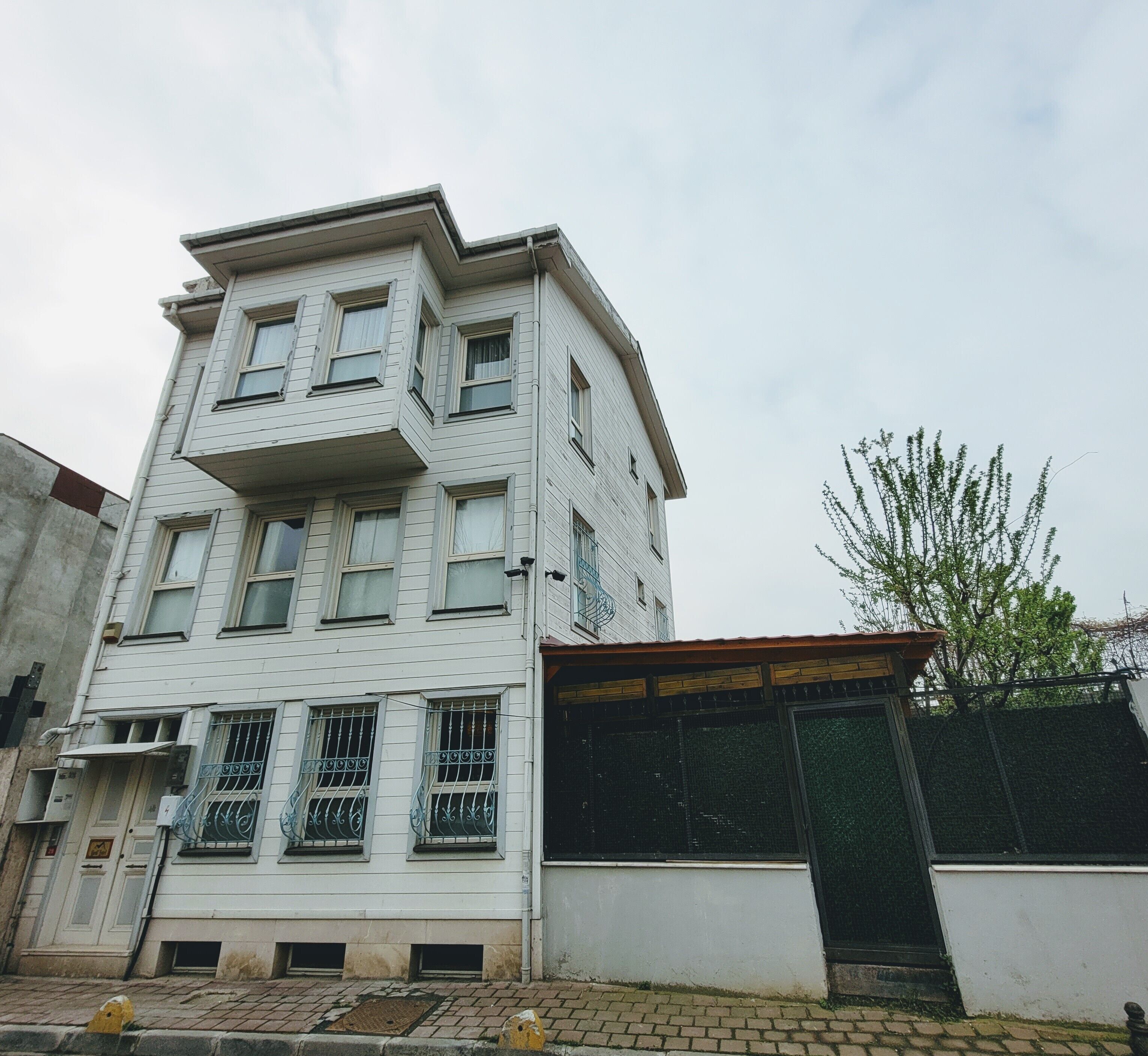 A multi-story building with a flat facade, multiple windows, and a gated entrance.