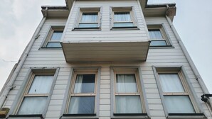 Ein mehrgeschossiges Gebäude mit einer symmetrischen Fassade, zahlreichen Fenstern und einem zentralen Vordach.