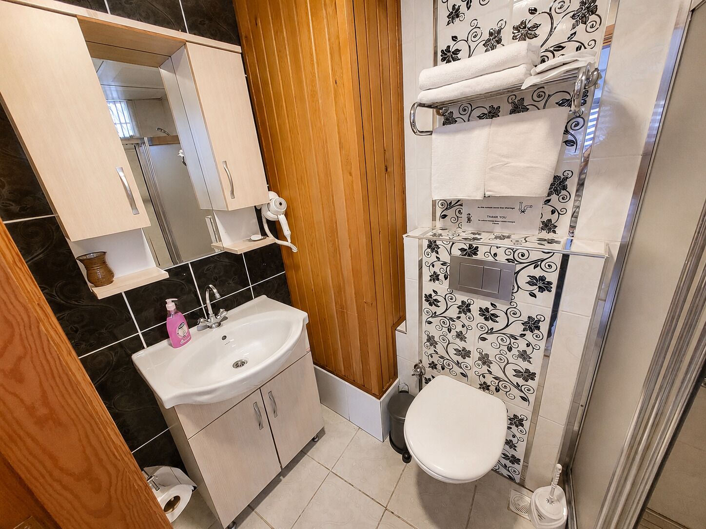 A bathroom with a sink, toilet, and a shower area.