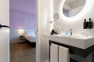 Een moderne badkamer met een grote spiegel, een wastafel en een haardroger.
