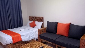 A room with two beds, a sofa, and a wooden coffee table.