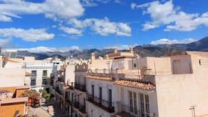 A cityscape with buildings, a clear sky, and mountains in the background. - Holiday Studio 'Lola' with Mountain View, Private Terrace, A/C & Wi-Fi (Nerja)