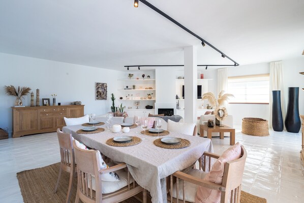 Un coin repas avec une table dressée pour quatre personnes, entourée de chaises en bois.