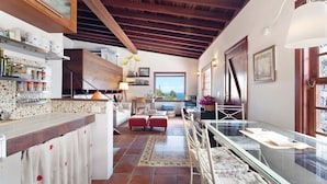 Una cocina con techo de madera, un comedor con vistas y una vitrina de vidrio.