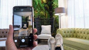 A smartphone displaying a room with a sofa, a chair, and a lamp. - Ibis Styles Santander  (Santander)