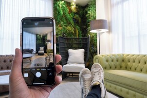 Un teléfono inteligente mostrando una habitación con un sofá, una silla y una lámpara.