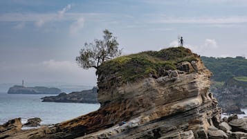 Una costa rocosa con un faro a lo lejos.