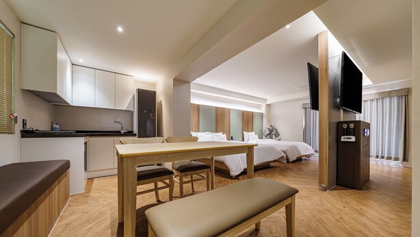 A modern hotel room with a kitchenette, a dining area, a bed, and a TV. - Brown Dot Hotel Eurwangri (Incheon)