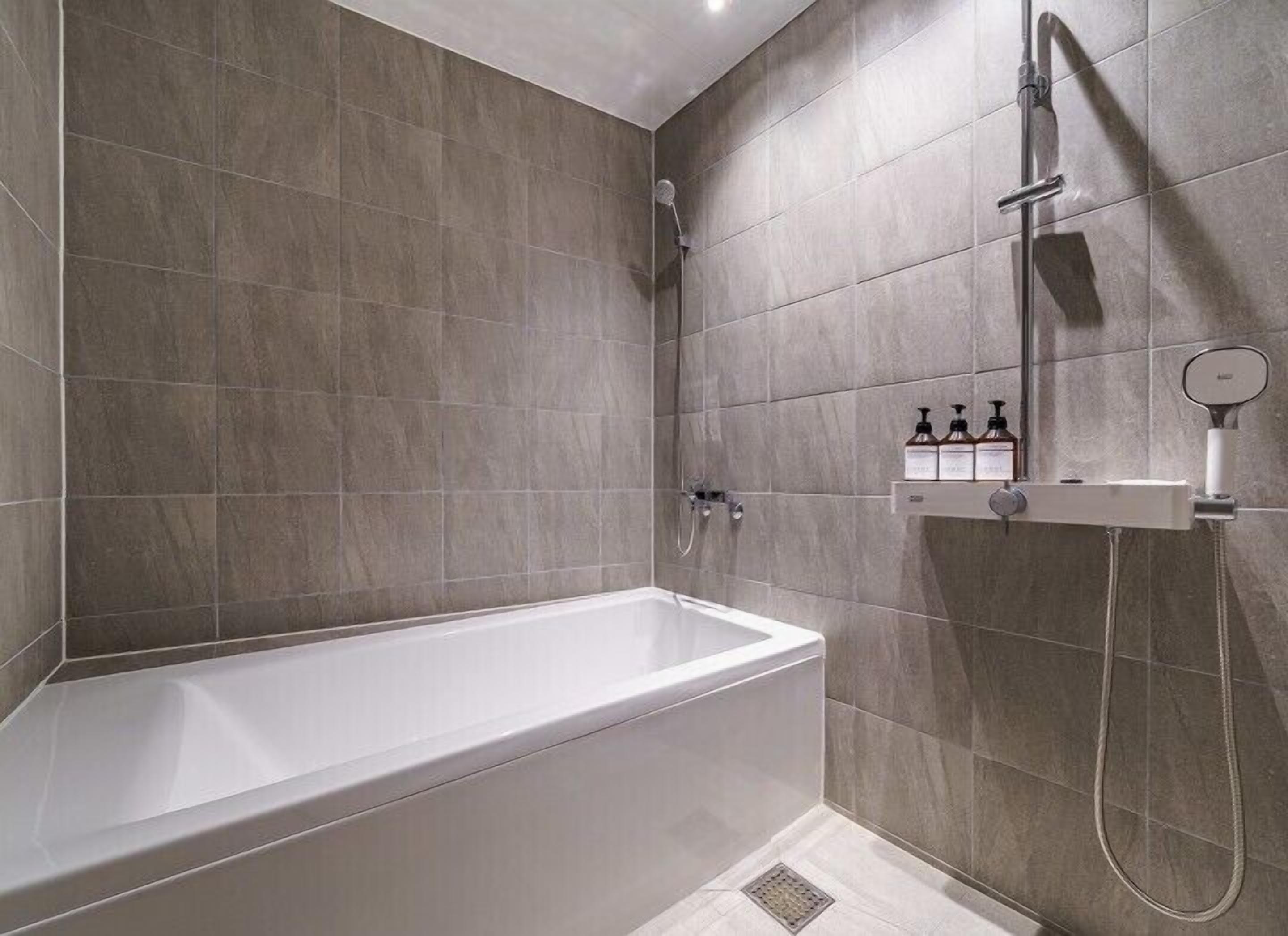 A modern bathroom with a bathtub, a shower, and a vanity with toiletries.