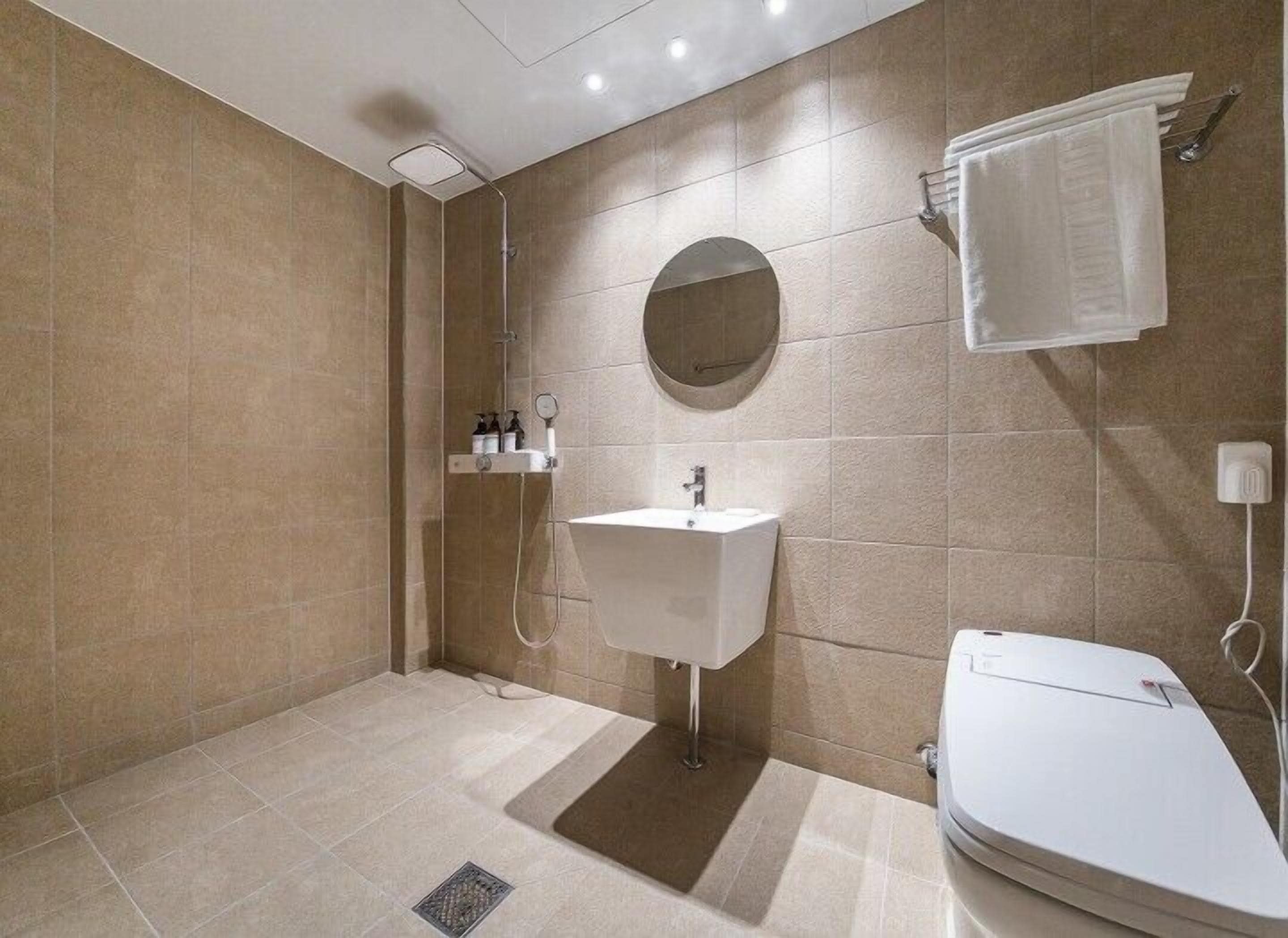 A modern bathroom with a shower, sink, and toilet.