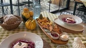 Una mesa de comedor con varios platos, incluyendo un bol de comida morada, una porción de papas fritas y una botella de agua.