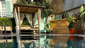 Una piscina cristalina con cubierta de madera y una marquesina.