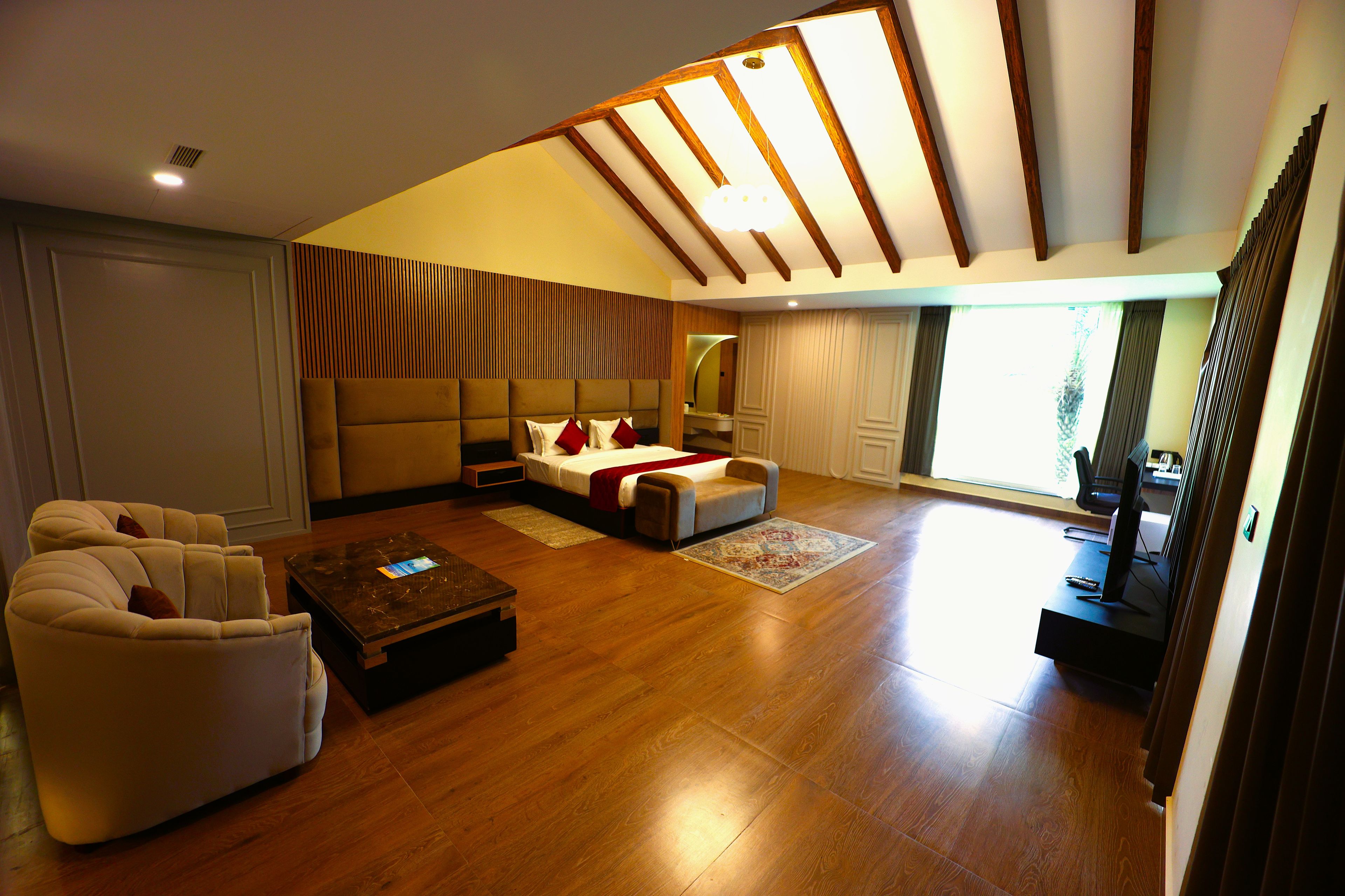 Un salon spacieux avec un plafond haut, un grand lit, un canapé et une table basse.