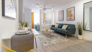 Un salon moderne comprenant un canapé, une table à manger et un élément de séparation décoratif.