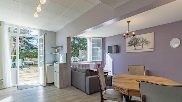 A modern interior with a dining area, sofa, and kitchen.