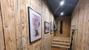 A wooden interior with framed pictures on the wall, a stone floor, and a staircase leading upwards. - COMFORTABLE CHALET - QUIET AND CLOSE TO EVERYTHING (Colmars)