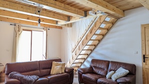 A cozy living room with two brown leather sofas, a wooden ceiling, and a sloped ceiling with a wooden staircase. - COMFORTABLE CHALET - QUIET AND CLOSE TO EVERYTHING (Colmars)