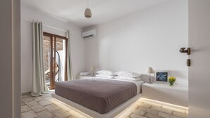 Una camera da letto moderna con un letto, un comodino, una lampada e una cornice.