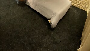 Ein Schlafzimmer mit Bett, Nachttisch und einer Steinwand.