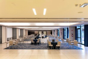 A large conference room with multiple tables and chairs, equipped with laptops and name tags, suggesting a business or event setting. - Doubletree BY Hilton Milan Malpensa (SOLBIATE OLONA)