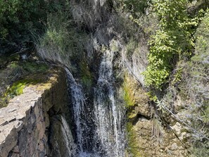 A natural waterfall cascading over rocky terrain surrounded by dense vegetation. - CAROLINAS'APARTMENT CARDEDU (Cardedu)