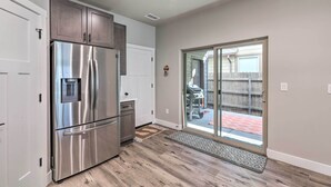 A modern kitchen with stainless steel appliances, a sliding glass door to a patio, and a wooden floor. - Modern Flagstaff Home, 4 Mi to Downtown! (Flagstaff)