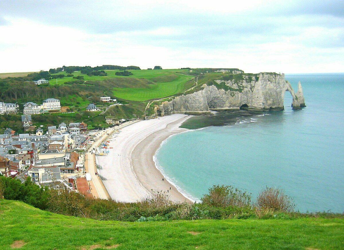 Une ville côtière caractérisée par une falaise imposante et une plage.