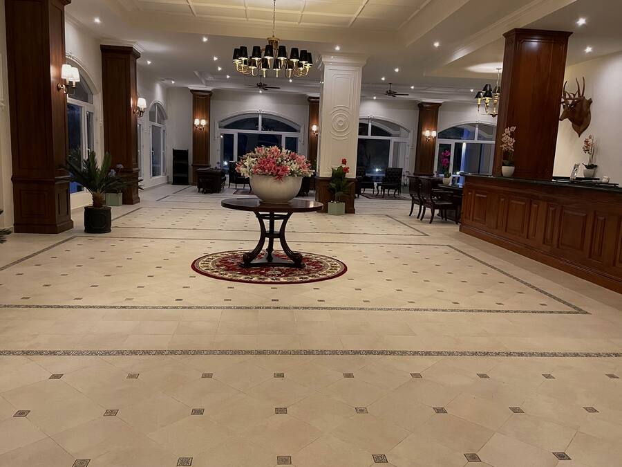 Un vestíbulo espacioso con una mesa redonda central, elegantes candelabros y un gran arreglo floral.