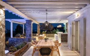Relax in the serene patio area, surrounded by lush greenery and a charming pergola.