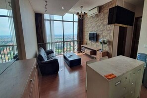 Ein modernes Wohnzimmer mit einer Couch, einem Couchtisch und einem an der Wand montierten Fernseher.