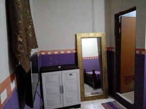 A room with a wardrobe, a mirror, and a bed. - Hotel Alifah 1 by Zuzu (Tangerang)