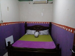 A small, narrow room with a single bed, purple walls, and a green bedspread. - Hotel Alifah 1 by Zuzu (Tangerang)