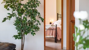 A room with a bed, a bedside table, and a potted plant. - Vacation Villa "La Quercia★ Swimming Pool-BBQ-Nature (Carbognano)