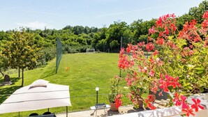 A grassy outdoor area with a soccer goal, potted plants, and a white umbrella. - Vacation Villa "La Quercia★ Swimming Pool-BBQ-Nature (Carbognano)