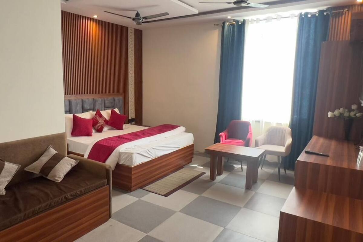 Habitació d'hotel amb un llit, un sofà, un escriptori i una cadira.