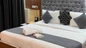 Ein modernes Schlafzimmer mit einem großen Bett, Holzvertäfelung an den Wänden, einem gepolsterten Kopfteil und einer Nachttischlampe.