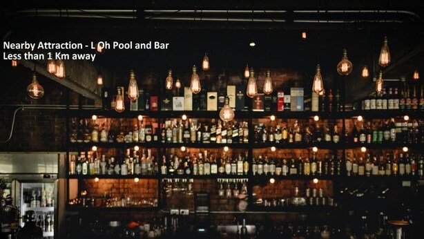 A bar with multiple shelves of liquor bottles, hanging light fixtures, and a bar counter with various bar tools. - Hotel Crystal Inn (Mumbai)