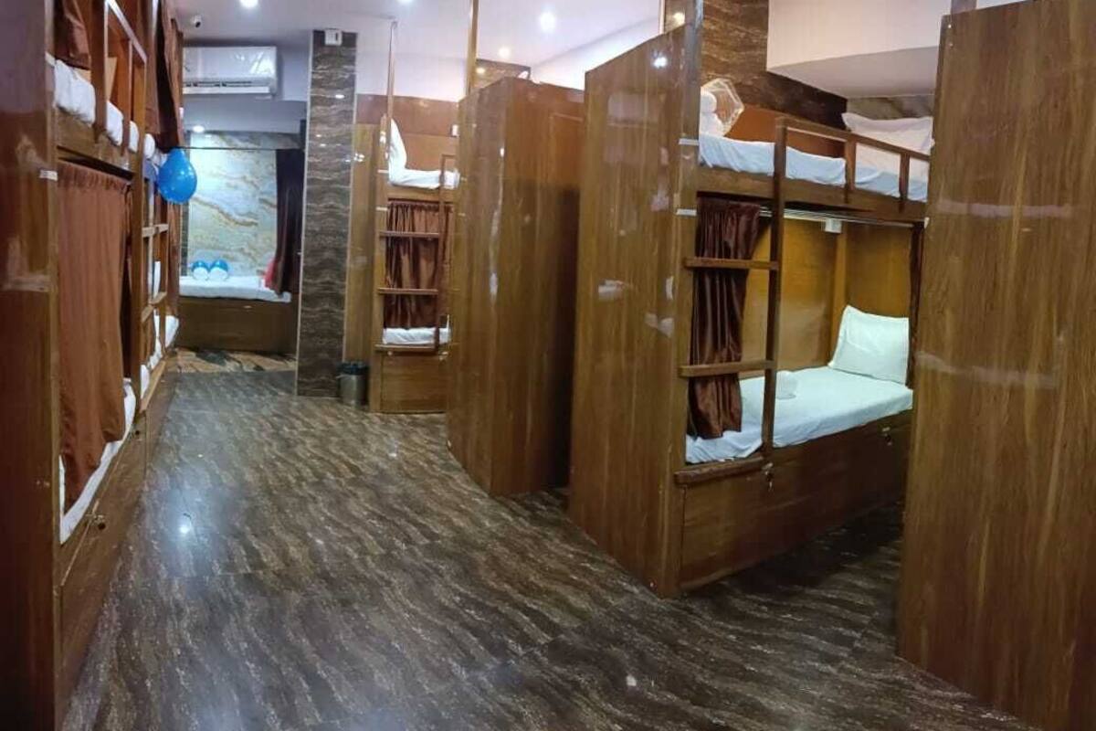 A hotel room with bunk beds, wooden furniture, and a marble floor.