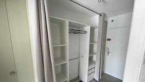 A walk-in closet with open shelves and a door leading to another room. - Charming apartment 2 minutes from the beach (Vallauris)