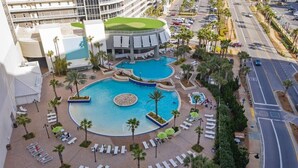 A hotel with multiple swimming pools, sun loungers, and palm trees. - Laketown Wharf 822- 2BR, Oceanview (Panama City Beach)