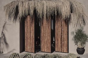 Un bâtiment doté d’un toit de chaume et de panneaux verticaux en bois.