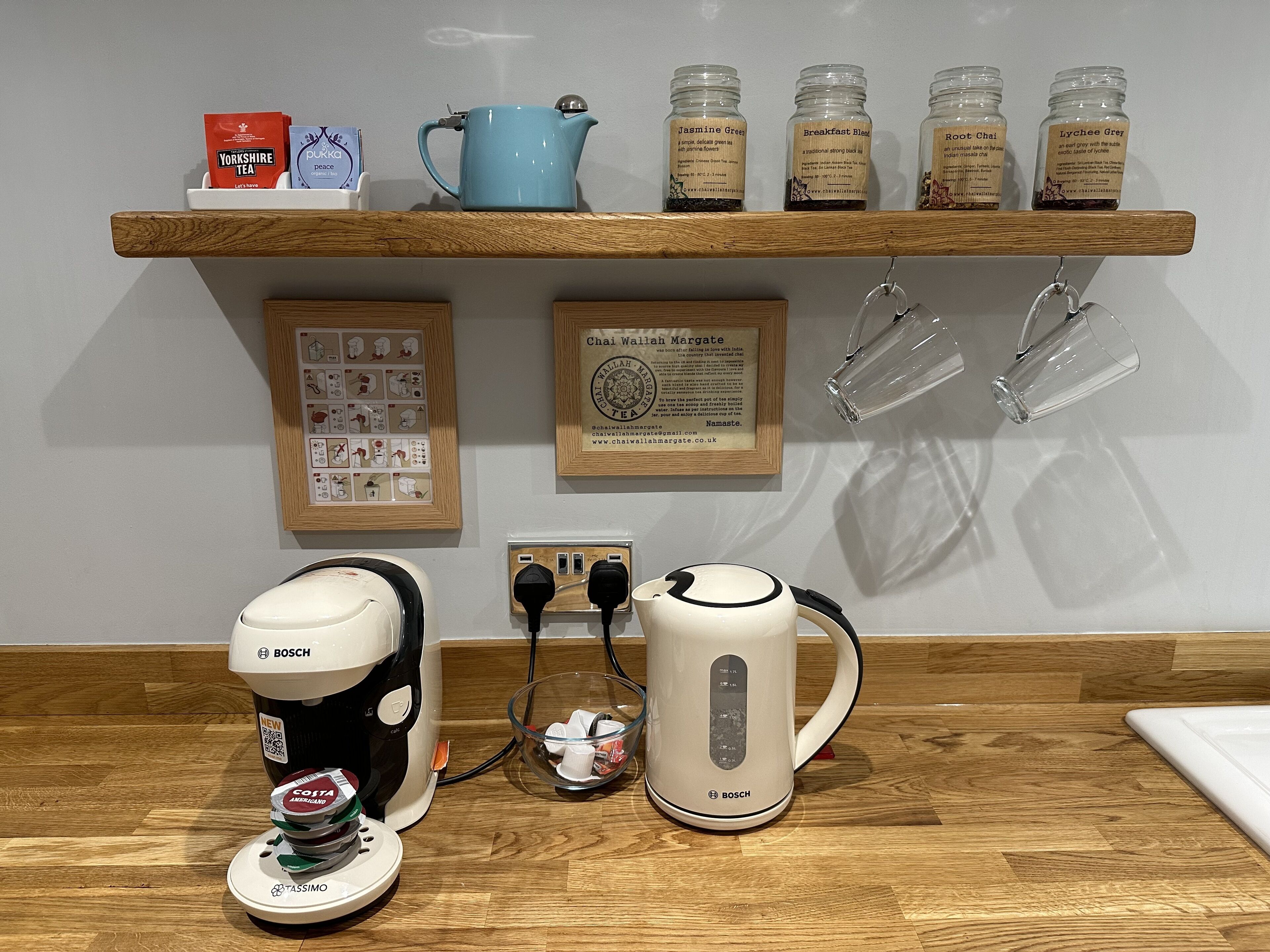 A kitchen counter with a coffee maker, a kettle, and tea bags.