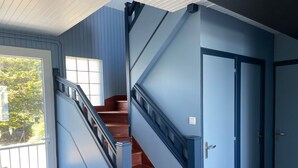A staircase with blue walls and wooden steps leading to a door.