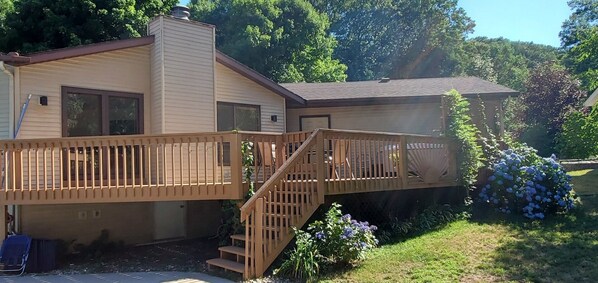 Stunning two-story residence with a spacious deck and beautifully manicured lawn.