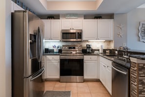 Enjoy cooking in this well-equipped kitchen with a refrigerator, microwave, oven, and coffee maker.
