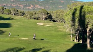 A golf course with a clear view of the surrounding landscape, including trees and distant hills. - Villa Golf Saint Endréol La Motte (La Motte)