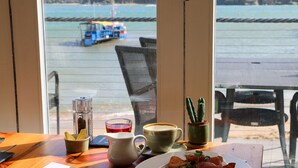 A dining table with a plate of food, a pitcher, a cup, and a glass of tea. - South Sands Hotel (Salcombe)