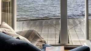 A room with a large window overlooking a body of water with boats. - South Sands Hotel (Salcombe)